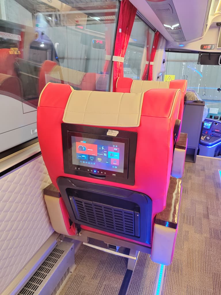 Seat-back entertainment screen in red/beige VIP cabin